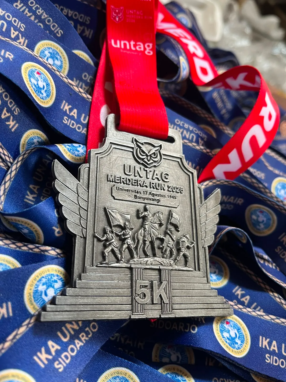 Medali finisher UNTAG Merdeka Run 5K dengan pita cetak